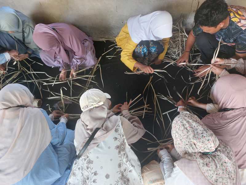 Wisatawan dengan program live in village menginap di homestay beraktifitas belajar menganyam daun lain bersama warga lokal Desa Terong.